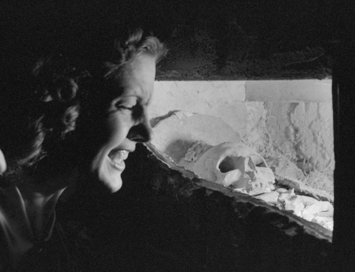 A woman looking at a plaster skull.
