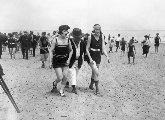 April 1922 Chicago, Illinois - Two bathers being escorted off the beach by a police woman.